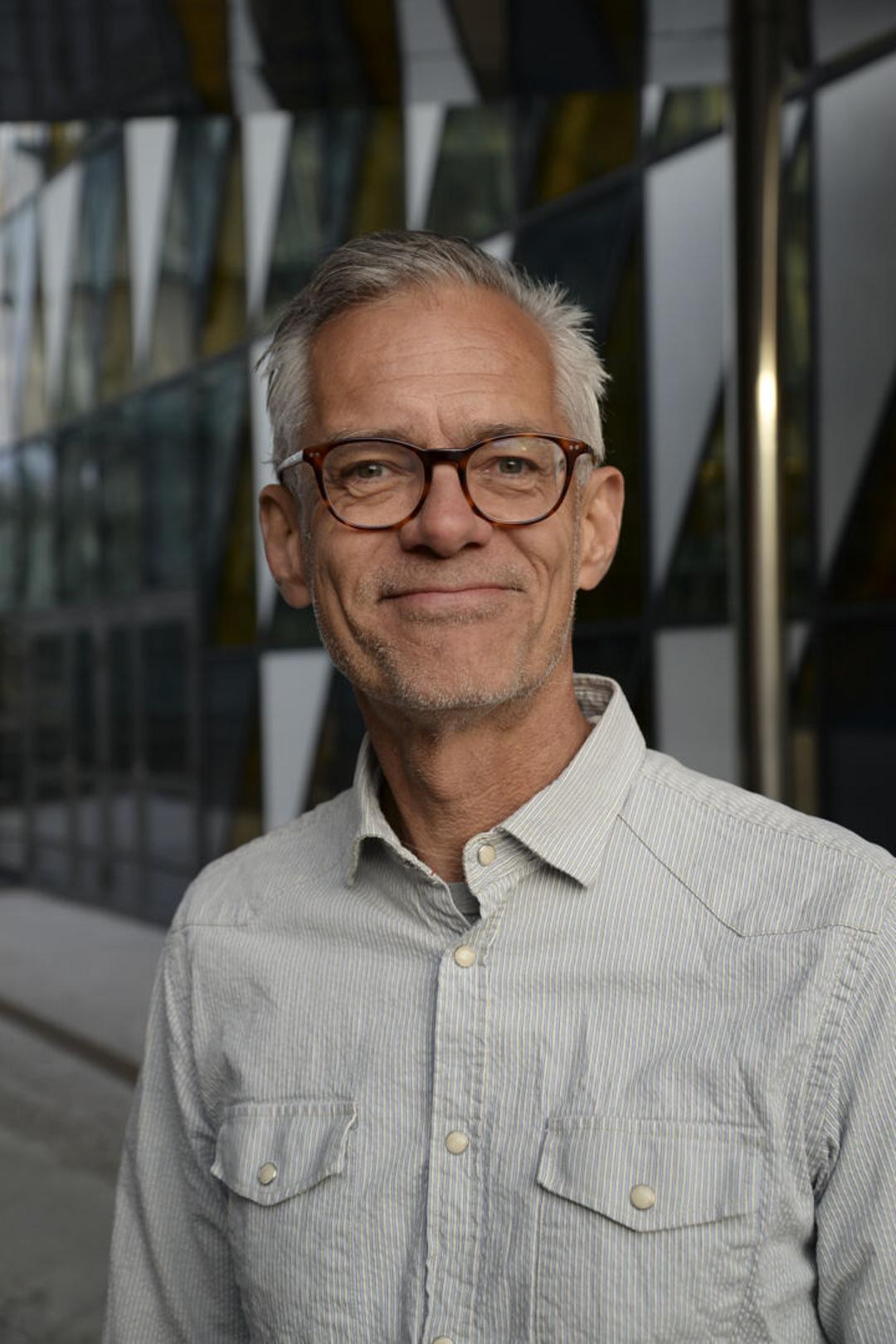 En man med glasögon och en denimskjorta