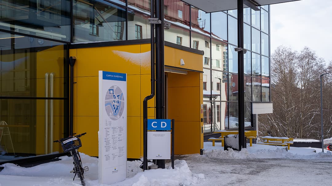 Glasbyggnad med gul entré