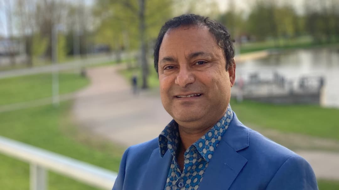 Koustuv Dalal står utomhus framför en parkmiljö.