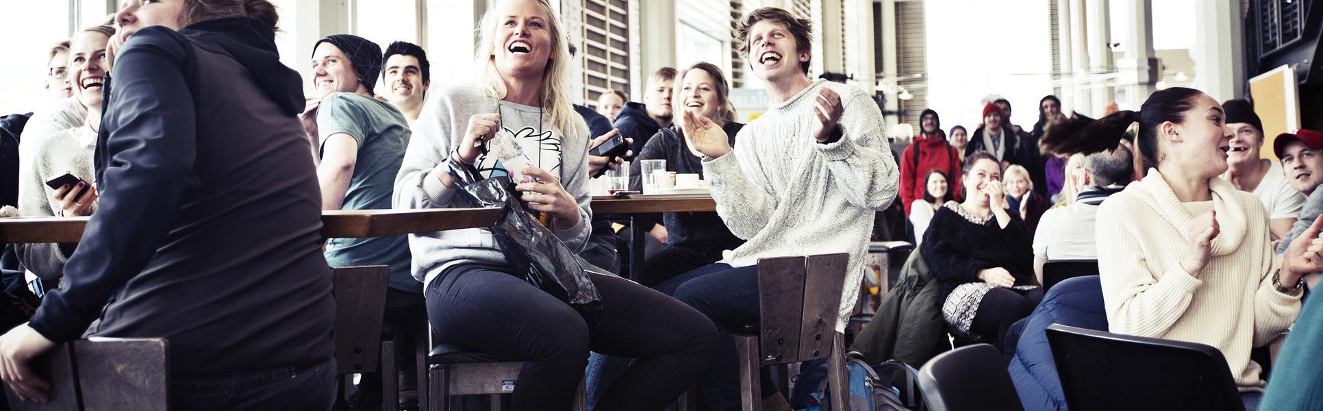 Studenter i Ljushallen som tittar på skidåkning. 