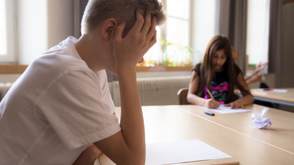Pojke kämpar med prov i skolan