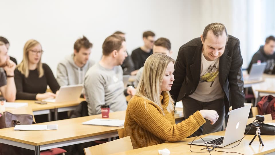 Klassrum – lärare hjälper student