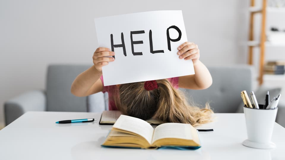 Tjej som läser och håller i en skylt med texten Help