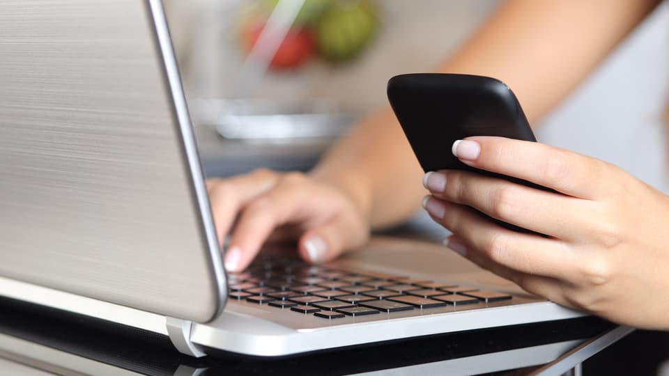 9994506-woman-hand-using-a-smart-phone-and-typing-a-laptop-at-home_resize_3840X5760_resize_3393X5760.jpg