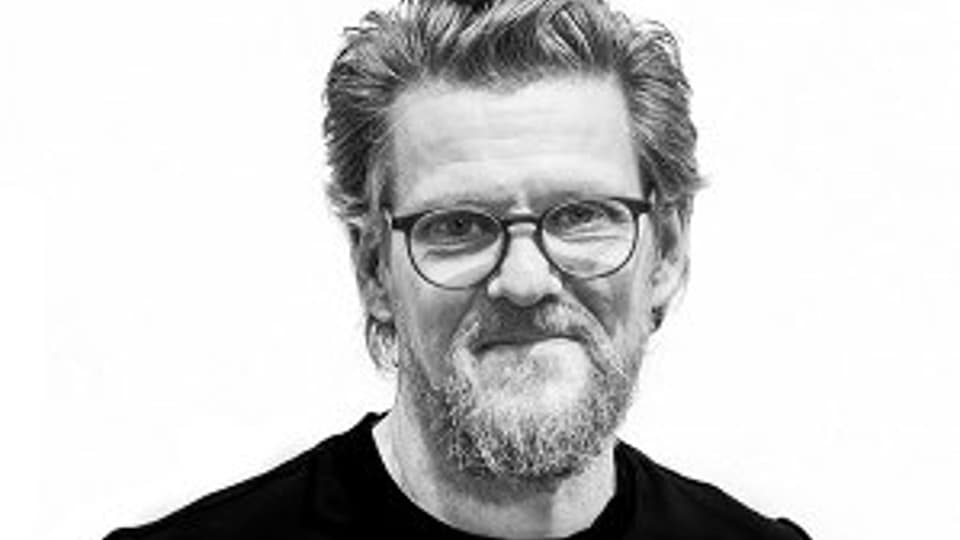 En man i glasögon som tittar på kameran