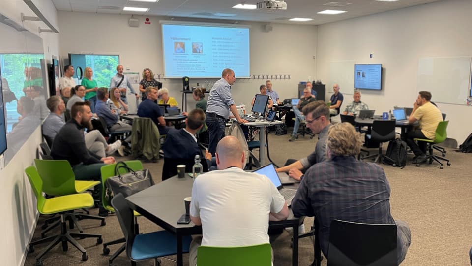 Many people in a room listening to a lecture.