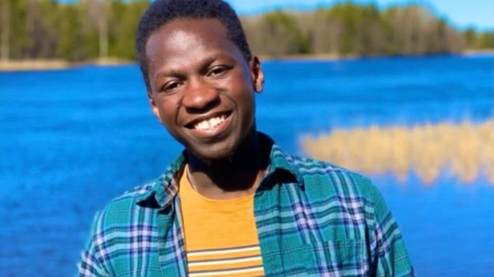 Nathan Kizito står framför en sjö