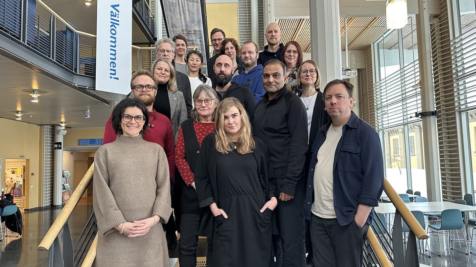 Många personer står samlade för gruppbild i en trappa.
