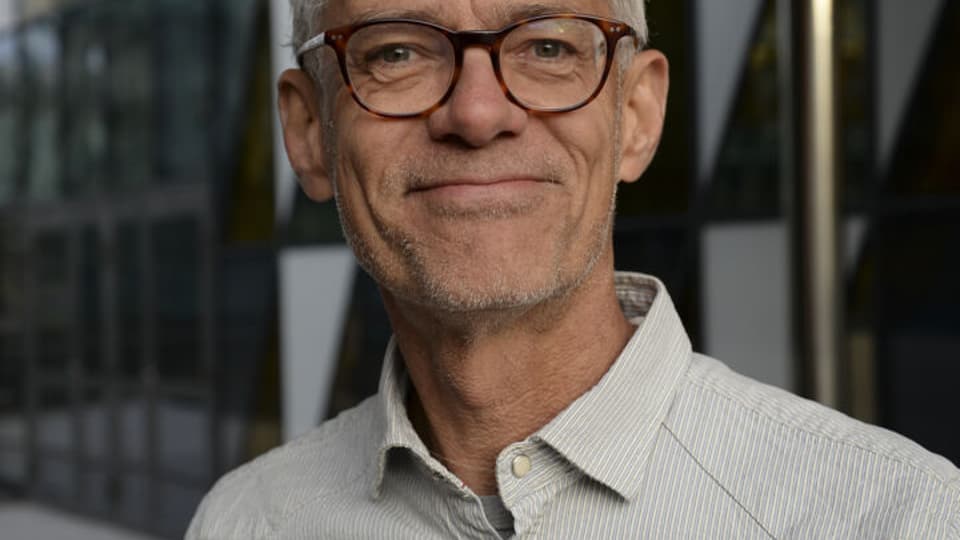 En man med glasögon och en denimskjorta