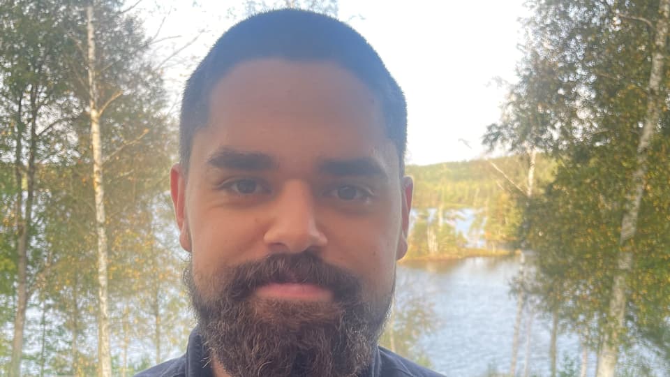 En man med skägg och svart skjorta