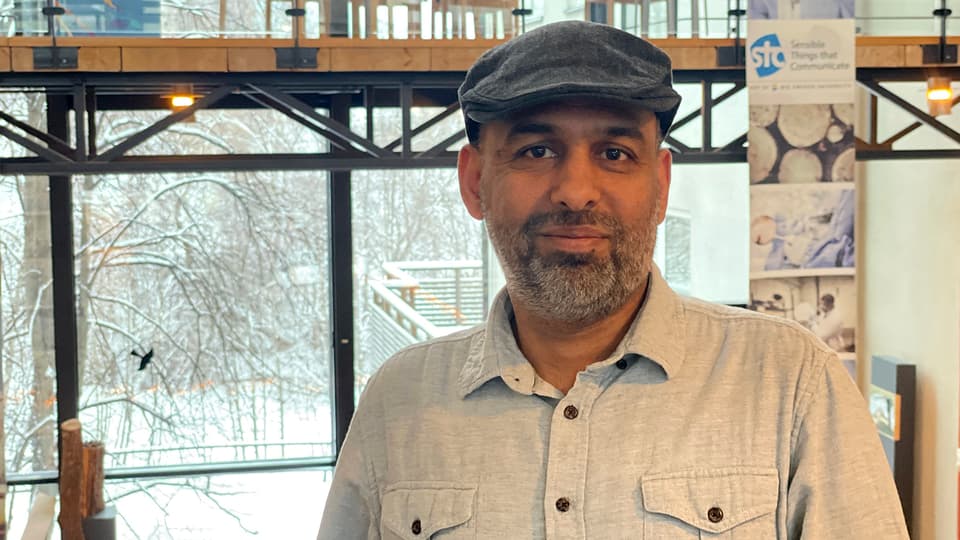Man in gray cap and light shirt poses in front of the camera.