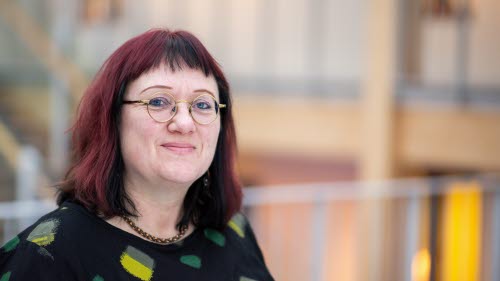 Woman with glasses and red hair.