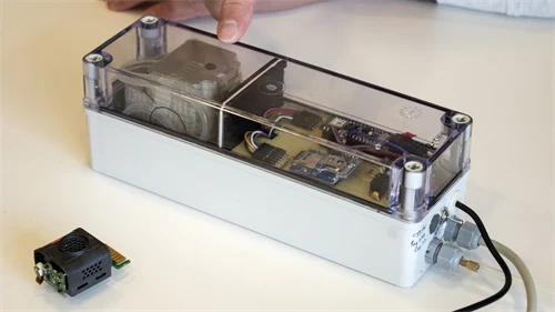 A rectangular box made of plastic with various electronic components.