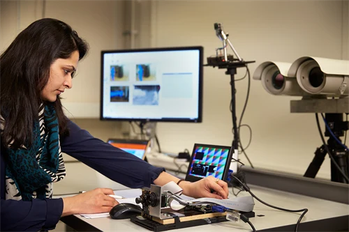 Woman using camera equipment in a lab.