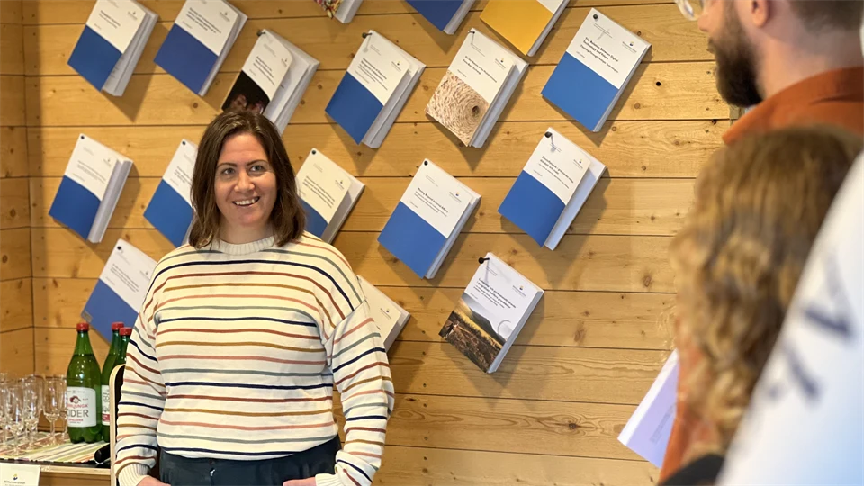 Karin Larsson-Hult står framför en vägg av uppspikade avhandlingar