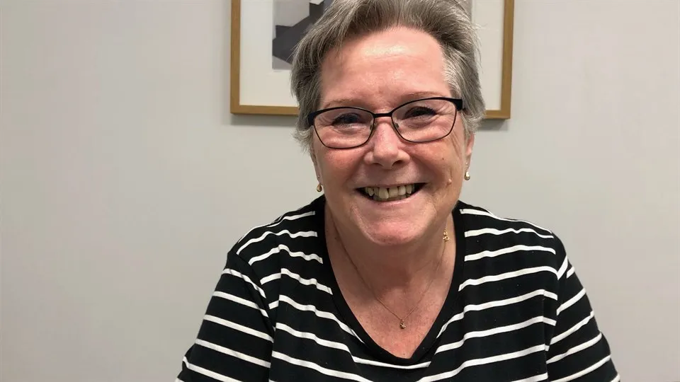 Lena Jonsson sitter på sitt kontor. Hon ser glad ut.