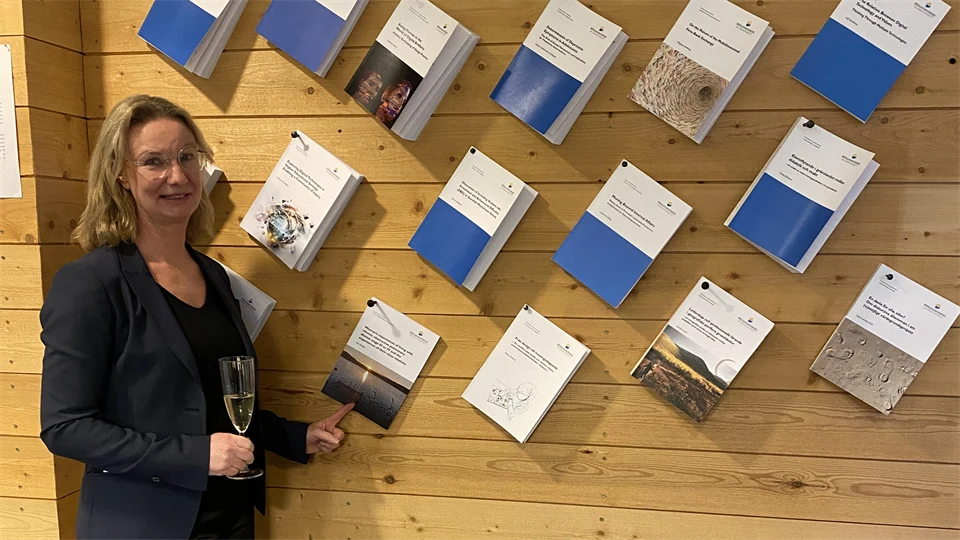 Kvinna bredvid en vägg med uppspikade böcker.