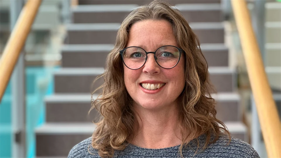 En kvinna med brunt hår och glasögon