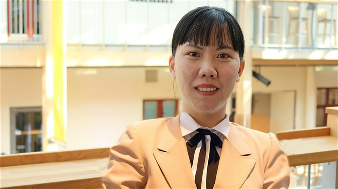 Asiatisk kvinna poserar framför kameran.