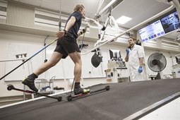 Alfred Buskqvist åker rullskidor på rullband med testutrustning som mäter syreupptagning, övervakas av testledare Hampus Lindblom.