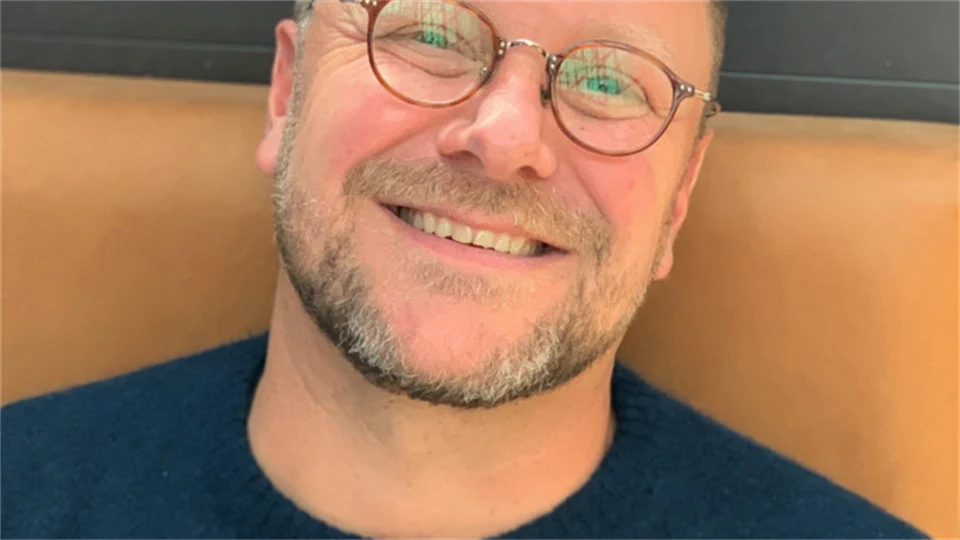 En man med glasögon och svart tröja