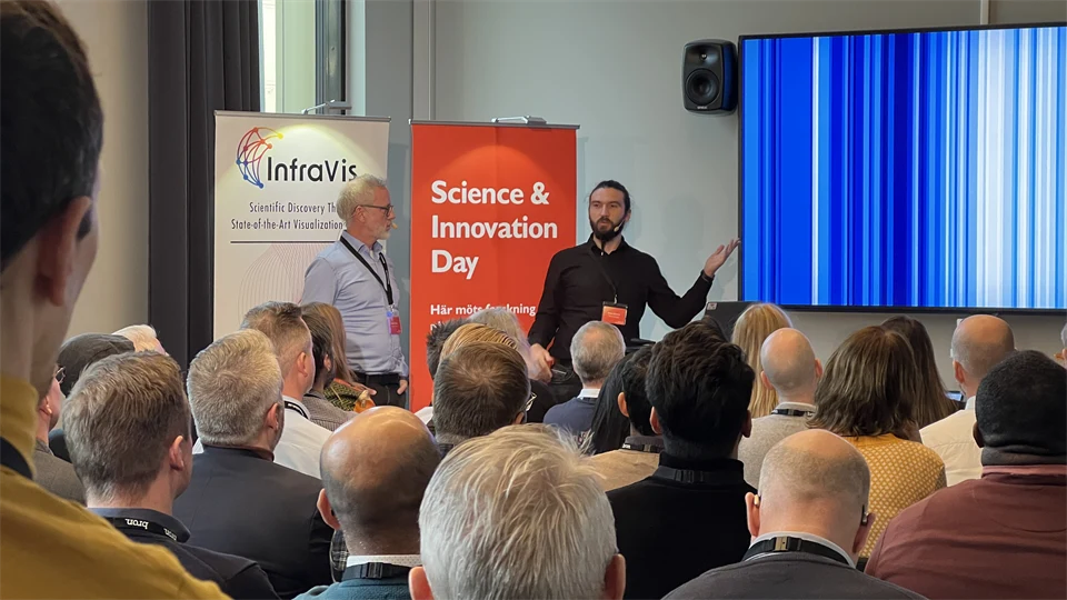 two men talking in front of an audience