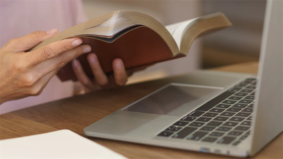 En oidentifierad person med lila tröja läser en bok