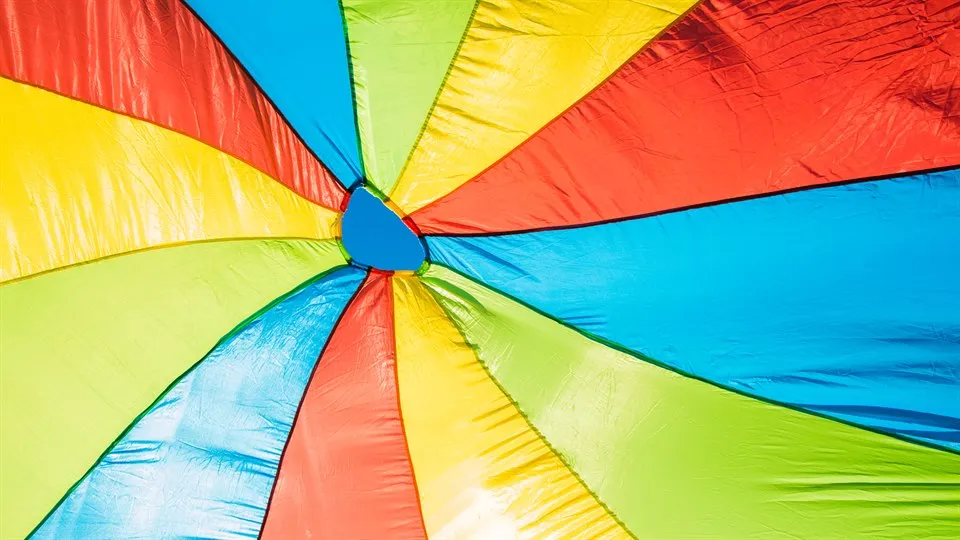 Färgglad fallskärm i regnbågsfärger