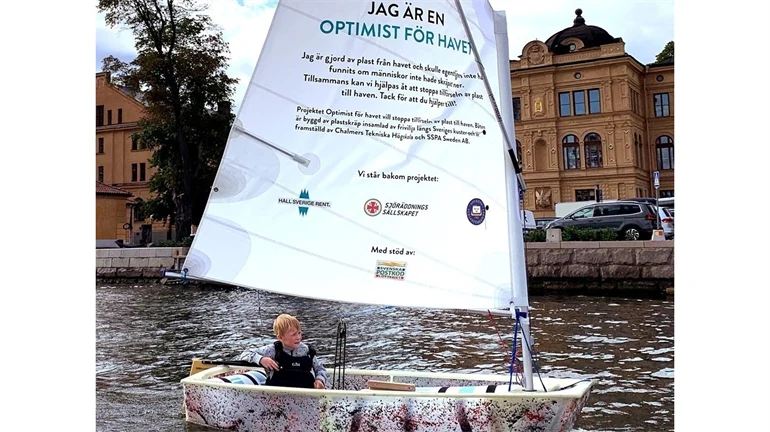 Optimistjolle gjord av plast med skräpa-inte-ned-budskap på seglet