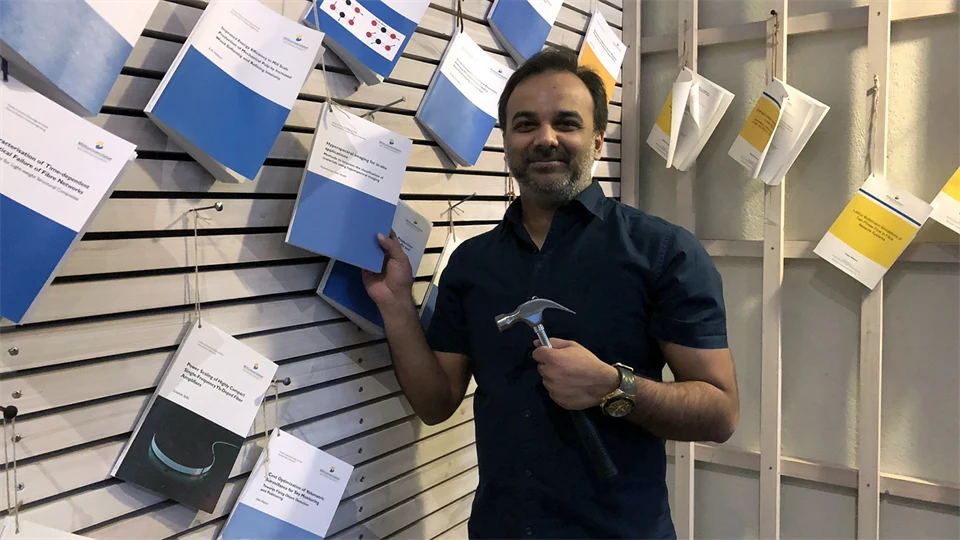 A man standing by a wall with theses nailed up