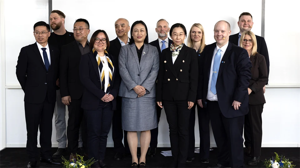 Group of men and women in front of white wall