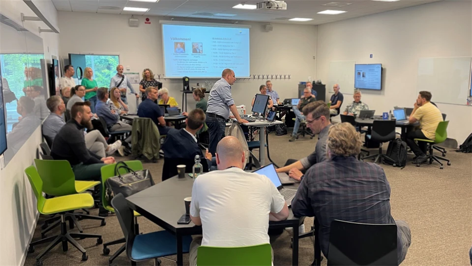 Many people in a room listening to a lecture.