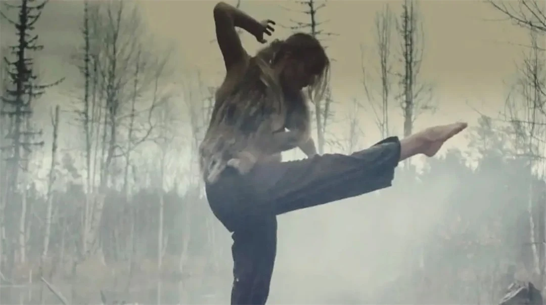 Kvinna dansar i naturen omgiven av rök