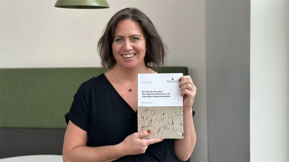 Karin Larsson-Hult håller upp sin avhandling