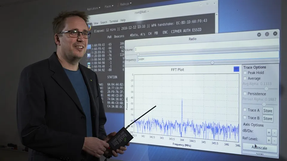 Man standing in front of a screen that show a diagram of a frequency.