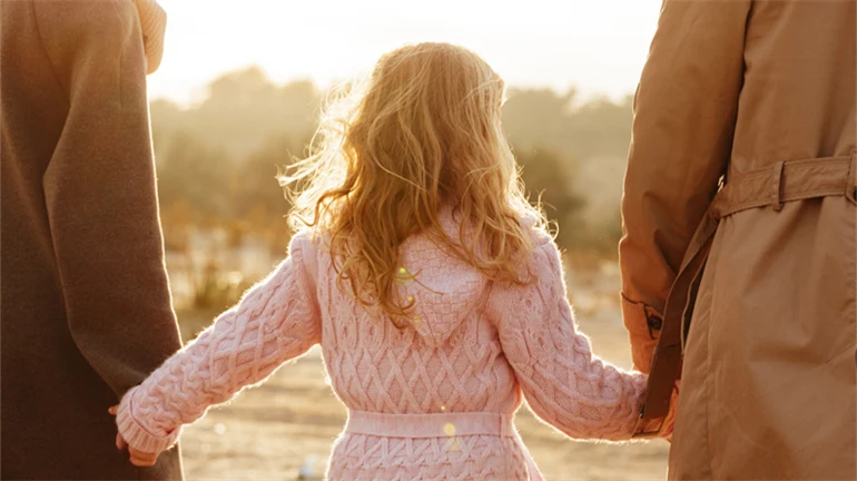 a woman, a child a man, seen from behind