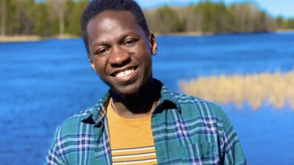 Nathan Kizito står framför en sjö