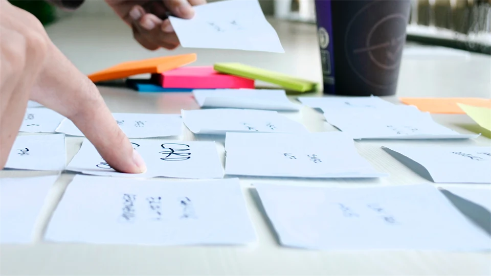 Two hands who arrange post it patches on a table