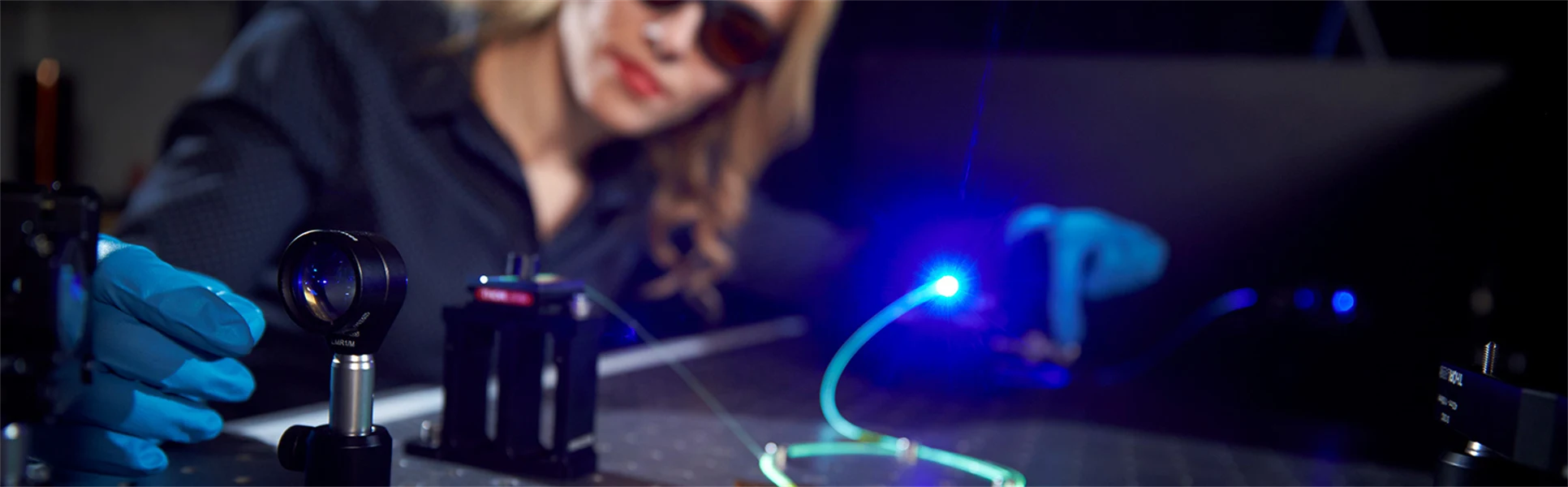 Enkeleda Balliu working with laser and fiber optic in the lab