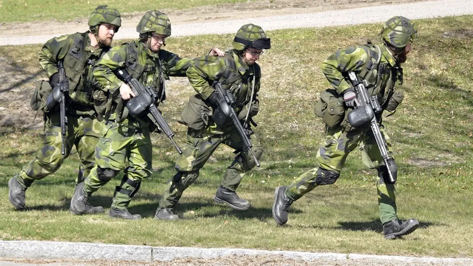 Militärer springer över ett fält