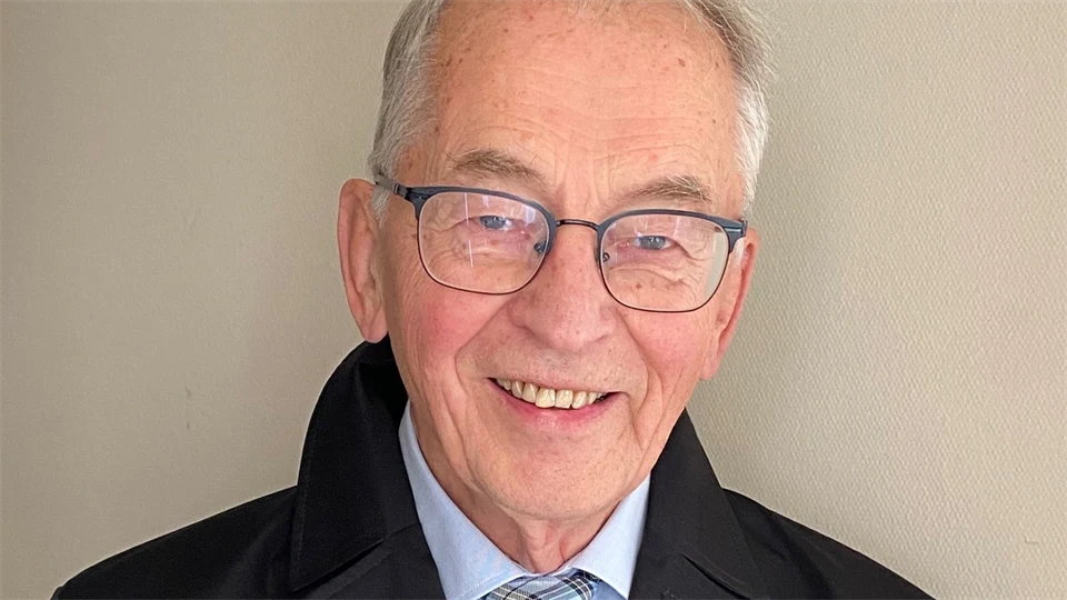 Äldre man i glasögon, med slips och mörk rock