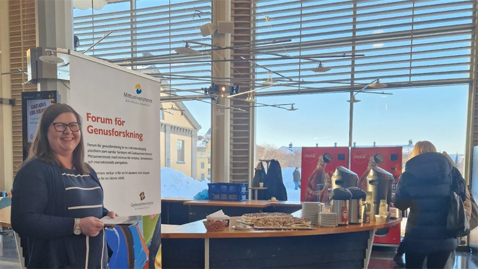 Ett bord med tårta samt en roll-up på campus i Östersund