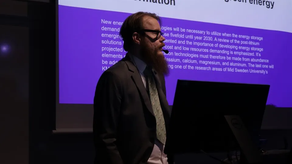 Man standing in front of a photo with text