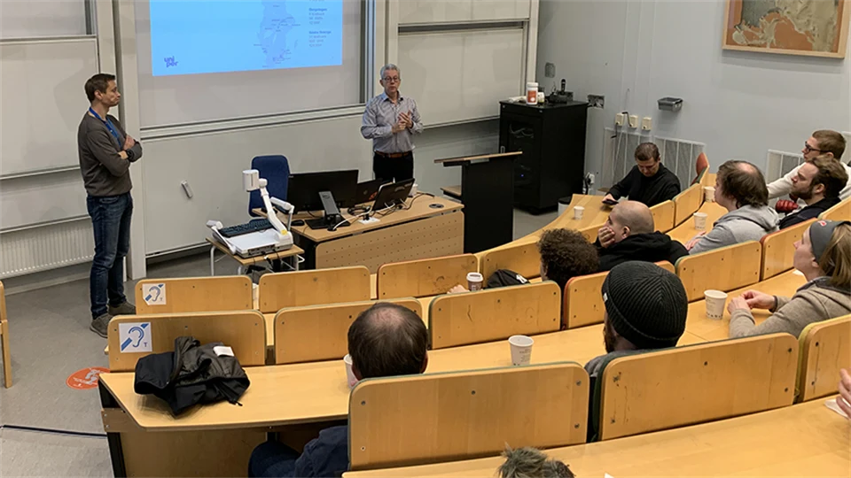 Students sit in a lecture hall and listen to a guest lecture.