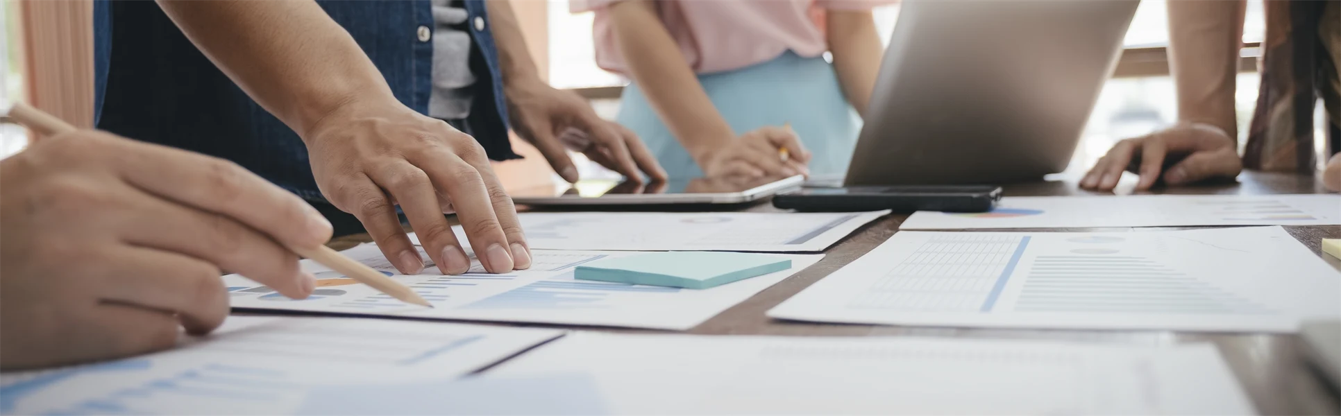 Bord med papper och människor som håller fram händerna