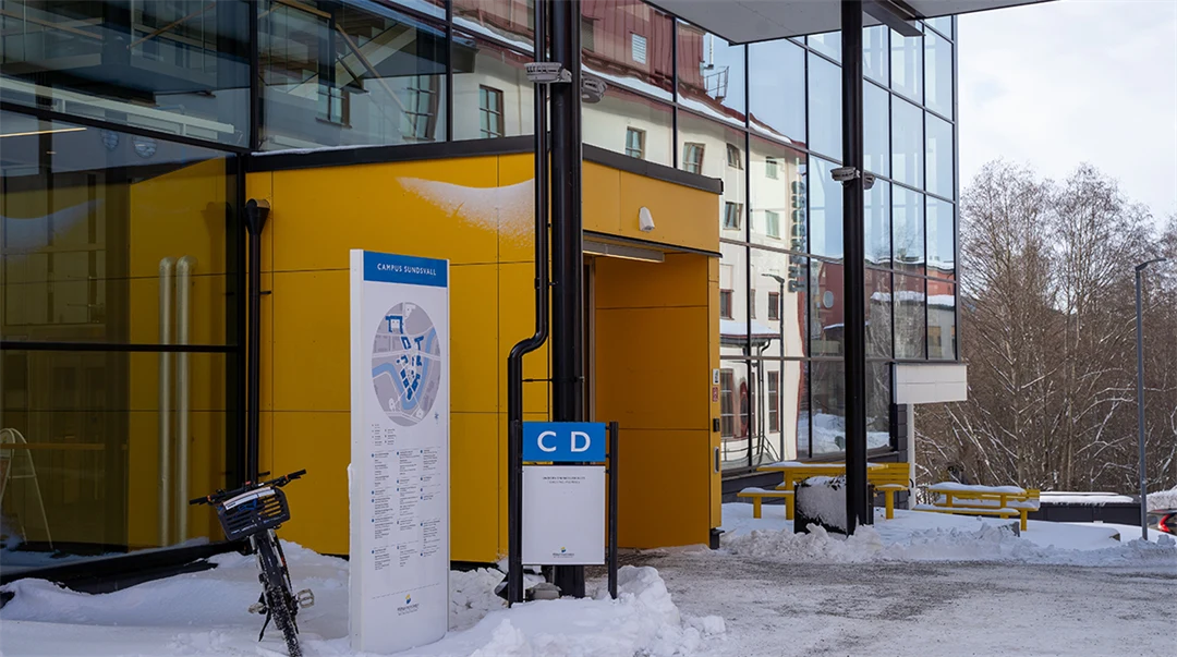 Glasbyggnad med gul entré