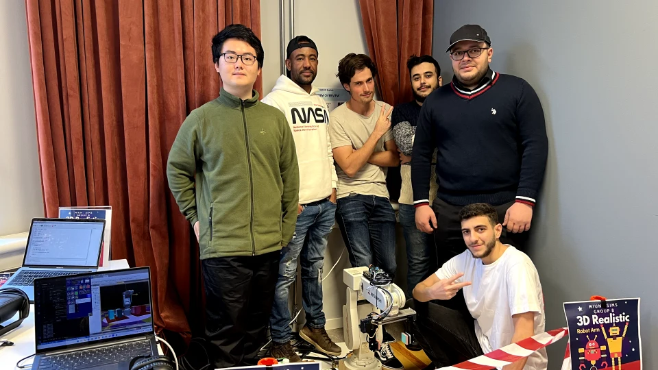 six people behind a robot arm