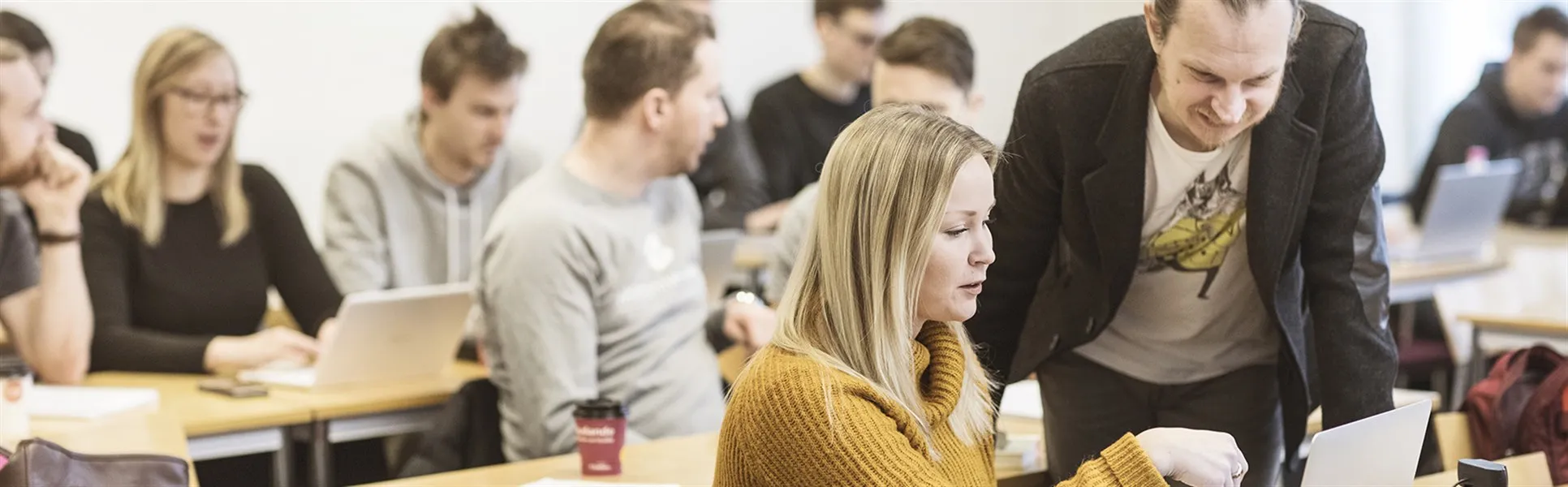 Klassrum – lärare hjälper student