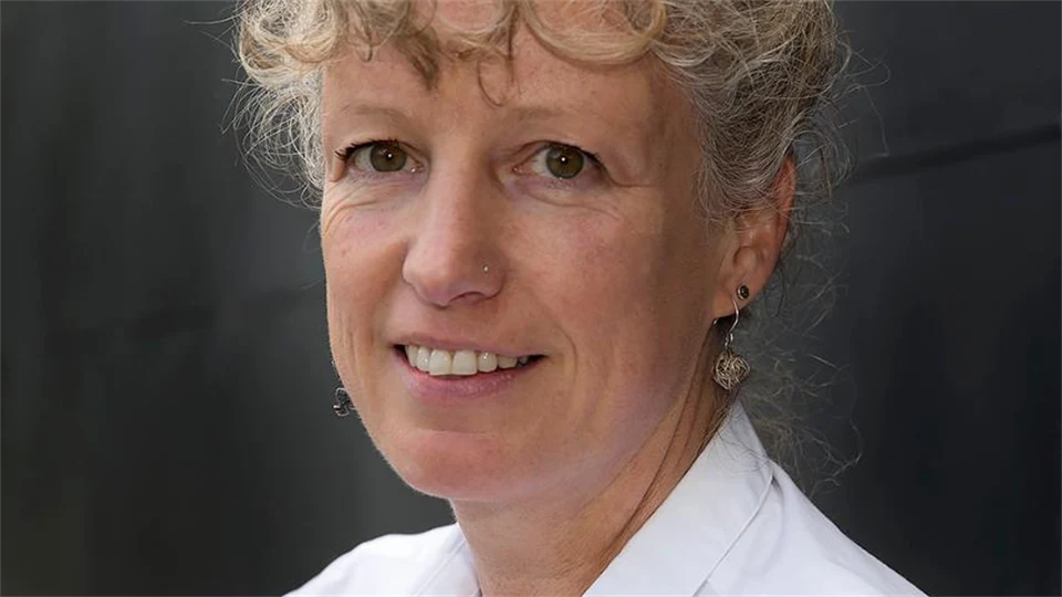 En kvinna i ljust hår i en vit skjorta