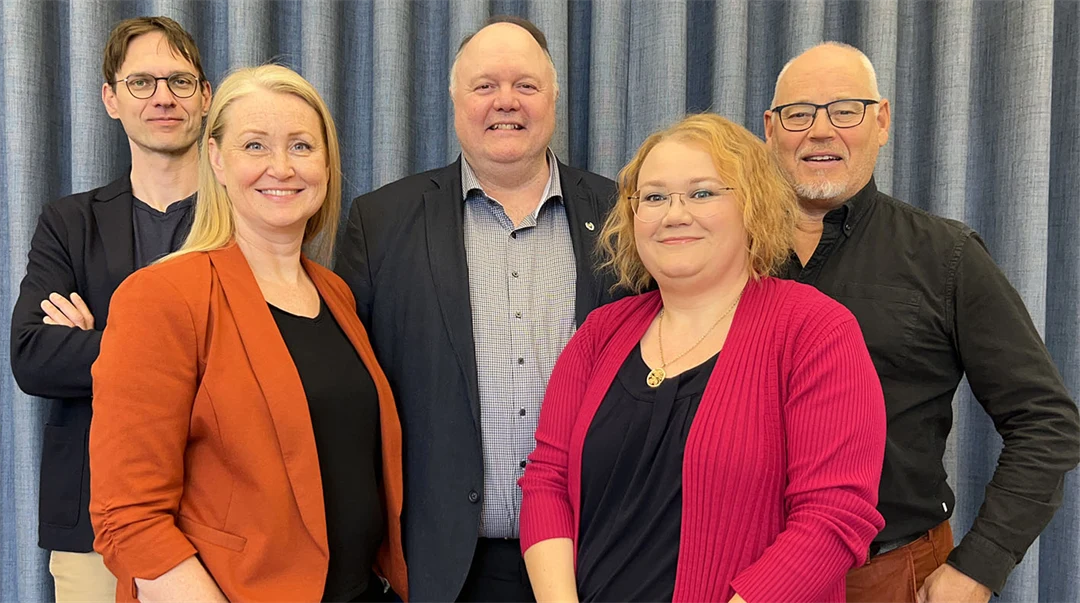 Fem personer, två kvinnor och tre män står uppställda för gruppfoto.